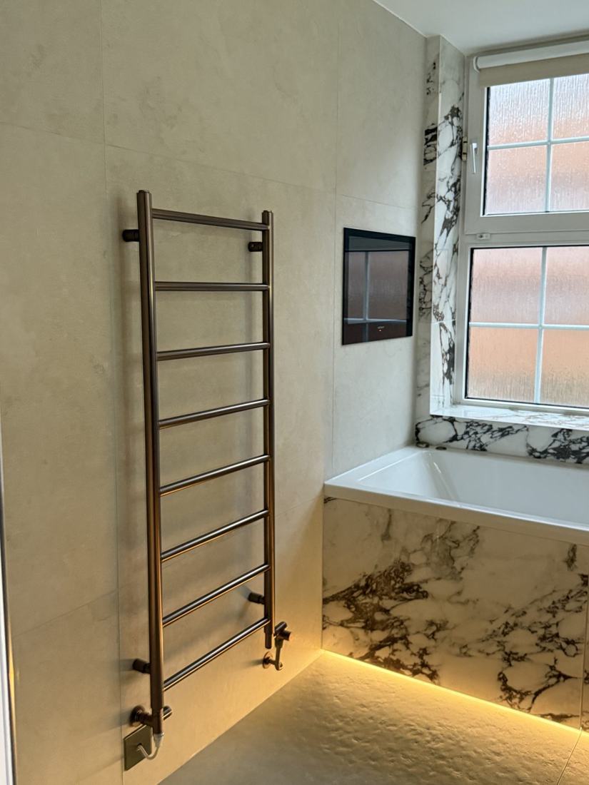 Bronze towel rail beside the fitted bath
